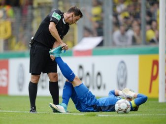 Schiedsrichter Christian Dietz hilft Torwart Dennis Klose, der mit einem Krampf auf dem Boden liegt. Foto: Patrick Seeger