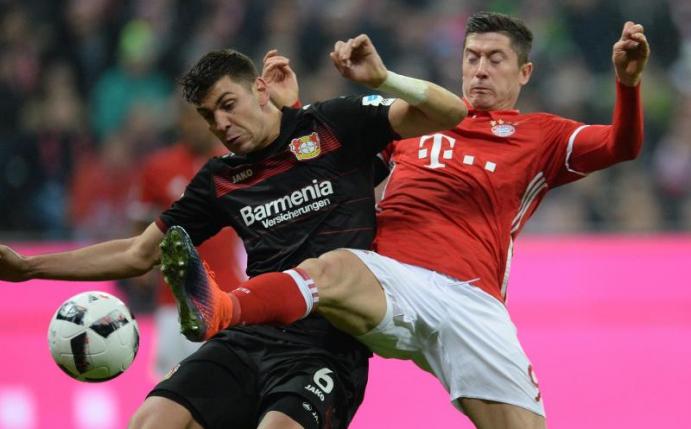 Eröffnen mit ihren Clubs die 55. Bundesliga Saison: Bayerns Robert Lewandowski (r) von München und der Leverkusener Aleksandar Dragovic. Foto: Andreas Gebert
