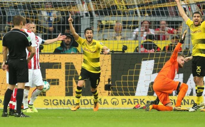 BVB-Profi Sokratis (2.v.r) erzielt das 2:0 gegen Köln. Schiedsrichter Patrick Ittrich (l) befragt den Video-Schiedsrichter. Foto: Ina Fassbender