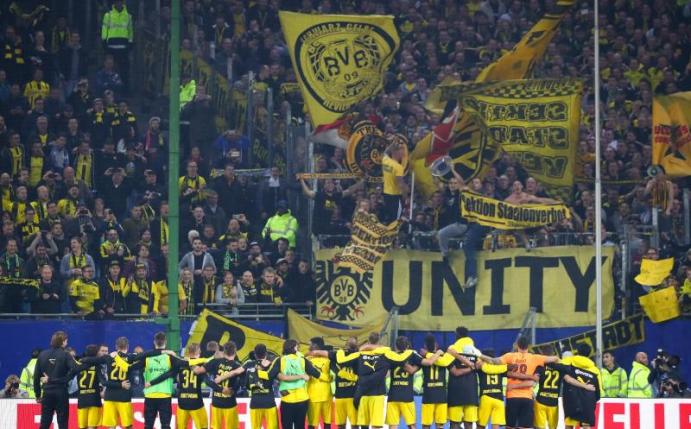 Die BVB-Spieler feiern den 3:0-Sieg beim HSV mit den Fans. Foto: Christian Charisius
