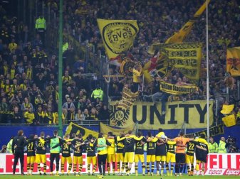 Die BVB-Spieler feiern den 3:0-Sieg beim HSV mit den Fans. Foto: Christian Charisius Die BVB-Spieler feiern den 3:0-Sieg beim HSV mit den Fans. Foto: Christian Charisius