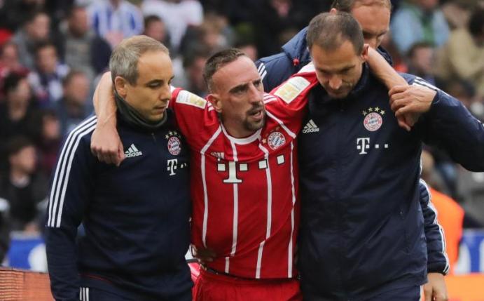 Franck Ribéry (M) wird von zwei Bayern-Medizinern in Berlin vom Platz begleitet. Foto: Michael Kappeler