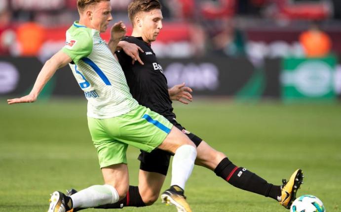 Der Wolfsburger Yannick Gerhardt (l) im Zweikampf mit dem Leverkusener Panagiotis Retsos. Foto: Marius Becker