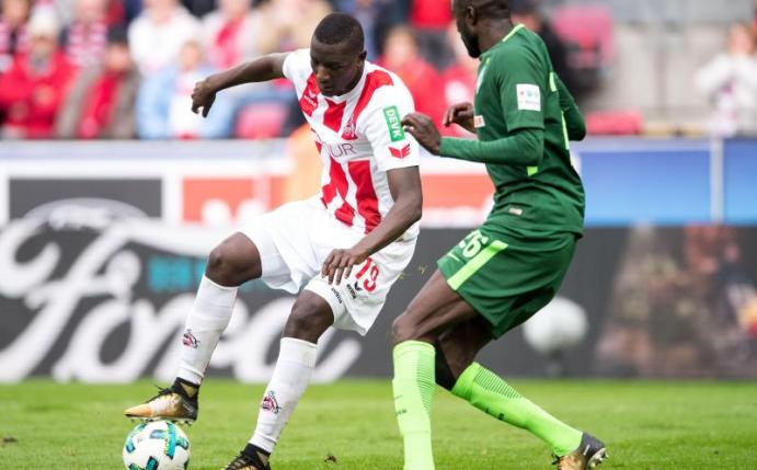 Der Kölner Stürmer Sehrou Guirassy (l) im Zweikampf mit Bremens Lamine Sané. Foto: Marius Becker