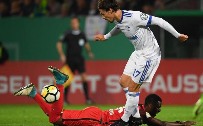 Wiesbadens Stephané Mvibudulu (unten) und der Schalker Benjamin Stambouli beim Zweikampf. Foto: Arne Dedert