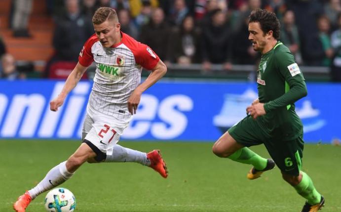 Augsburgs Torschütze Alfred Finnbogason (l) beim Zweikampf mit dem Bremer Thomas Delaney. Foto: Carmen Jaspersen