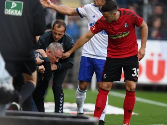 Freiburg-Trainer Christian Streich bekommt nach seinem Sturz gegen Schalke wieder auf die Beine geholfen. Foto: Patrick Seeger