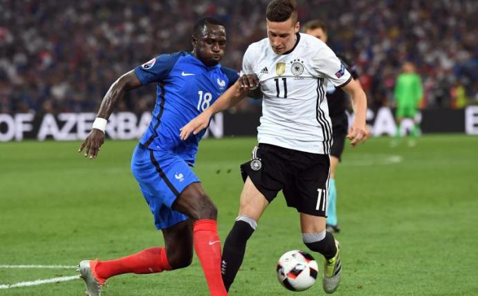 Deutschlands Nationalspieler Julian Draxler (r) bei der EM 2016 im Duell mit dem Franzosen Moussa Sissoko. Foto: Federico Gambarini