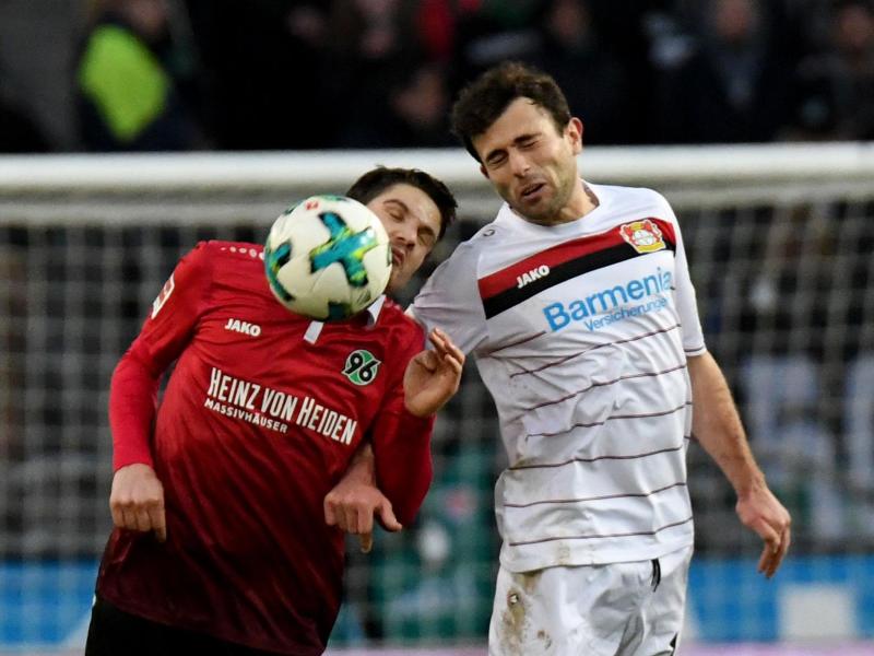 Hannovers Pirmin Schwegler (l) und Admir Mehmedi von Bayer Leverkusen kämpfen um den Ball. Foto: Peter Steffen