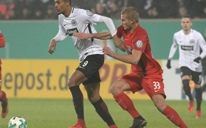 Heidenheims Timo Beermann (r) und Sebastien Haller von Eintracht Frankfurt kämpfen um den Ball. Foto: Stefan Puchner