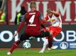 Nürnbergs Ewerton (l) blockt im Spiel gegen Jahn Regensburg einen Ball von Jann George. Foto: Daniel Karmann