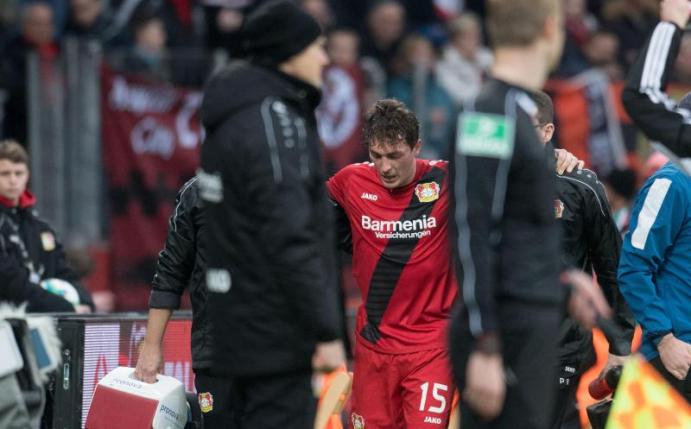 Leverkusens Julian Baumgartlinger (M,hinten) wird verletzt vom Platz begleitet. Foto: Bernd Thissen