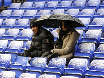 In Lpndon sitzen zwei Zuschauer im White Hart Lane Stadion im leichten Schneefall. Foto: Kerim Okten/EPA
