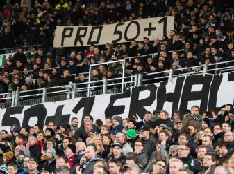 Fans von Hannover zeigen Plakate mit der Aufschrift "Pro 50+1". Foto: Swen Pförtner
