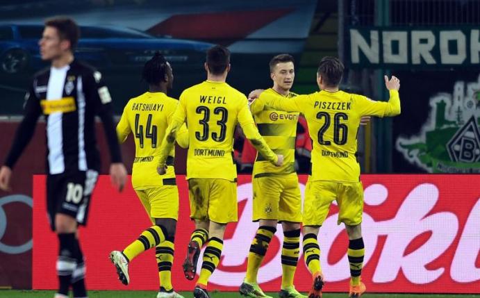 Die Dortmunder feiern das Tor des Tages durch Marco Reus zum 1:0 Auswärtssieg in Gladbach. Foto: Federico Gambarini