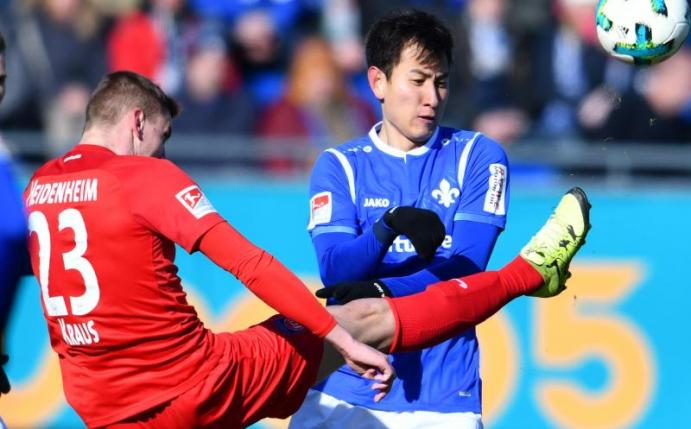 Heidenheims Kevin Kraus (l) und Darmstadts Dong-Won Ji kämpfen um den Ball. Foto: Uwe Anspach