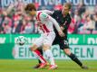 Kölns Yuya Osako (l) versucht den Ball gegen den Stuttgarter Holger Badstuber zu behaupten. Foto: Rolf Vennenbernd