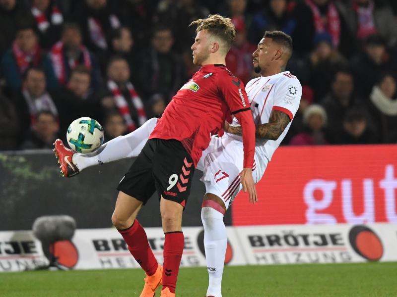 Freiburgs Lucas Höler (l) wird von Bayern-Verteidiger Jerome Boateng bei der Ballannahme gestört. Foto: Patrick Seeger