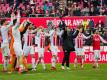 Die Spieler des 1. FC Köln feiern nach dem Abpfiff mit den Zuschauern den Sieg über Bayer Leverkusen. Foto: Rolf Vennenbernd