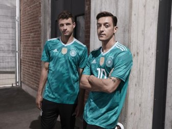 Alles auf Grün: Die Weltmeister Thomas Müller (l) und Mesut Özil präsentieren das neue Auswärtstrikot der DFB-Elf. Foto: adidas /dpa Alles auf Grün: Die Weltmeister Thomas Müller (l) und Mesut Özil präsentieren das neue Auswärtstrikot der DFB-Elf. Foto: adidas /dpa