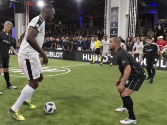 Kann es auch am Ball: Usain Bolt (l) beim Zweikampf mit Roberto Carlos (r). Foto: Georgios Kefalas