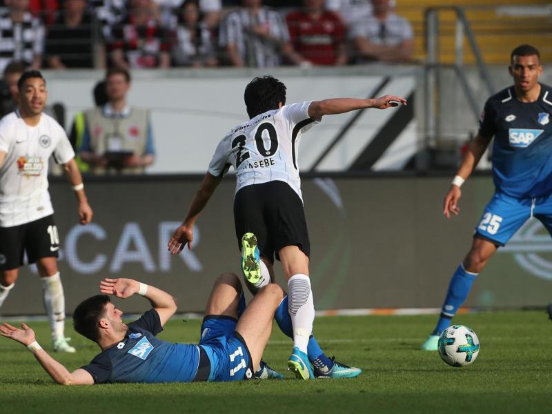 Der Frankfurter Makoto Hasebe (M) und Hoffenheims Florian Grillitsch (unten) kämpfen um den Ball. Foto: Thomas Frey