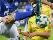 Im Hinrunden-Revierderby kämpfen der Dortmunder Raphael Guerreiro (r) und der Schalker Daniel Caligiuri (l) um den Ball. Foto: Friso Gentsch