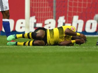 Dortmunds Michy Batshuayi liegt verletzt auf dem Spielfeld. Foto: Ina Fassbender