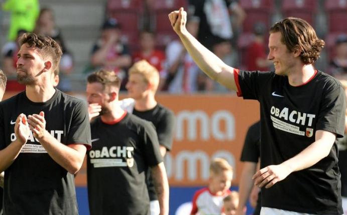 Die Augsburger Spieler feiern mit einem Spruch auf ihren Shirts den Klassenerhalt und das kommende 8. Bundesligajahr. Foto: Stefan Puchner