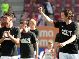 Die Augsburger Spieler feiern mit einem Spruch auf ihren Shirts den Klassenerhalt und das kommende 8. Bundesligajahr. Foto: Stefan Puchner Die Augsburger Spieler feiern mit einem Spruch auf ihren Shirts den Klassenerhalt und das kommende 8. Bundesligajahr. Foto: Stefan Puchner