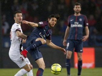 Doppeltorschütze Edinson Cavani (M) von Paris St. Germain im Zweikampf mit Guingamps Christophe Kerbrat (l). Foto: Thibault Camus/AP