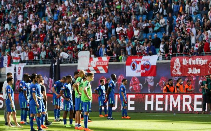 Nach der Niederlage in Leipzig stehen die Wolfsburger Spieler deprimiert vor ihren aufgebrachten Fans. Foto: Jan Woitas