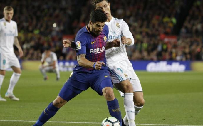 Barcelonas Luis Suarez und Reals Cristiano Ronaldo (r) führen einen harten Zweikampf. Foto: Emilio Morenatti/AP