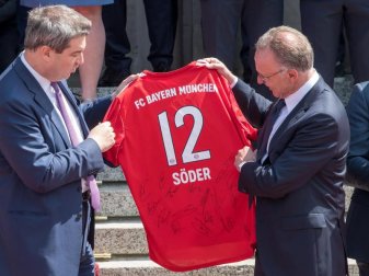 Karl-Heinz Rummenigge überreicht Markus Söder ein Trikot mit der Nummer 12 und der Aufschrift «Söder». Foto: Peter Kneffel Karl-Heinz Rummenigge überreicht Markus Söder ein Trikot mit der Nummer 12 und der Aufschrift «Söder». Foto: Peter Kneffel