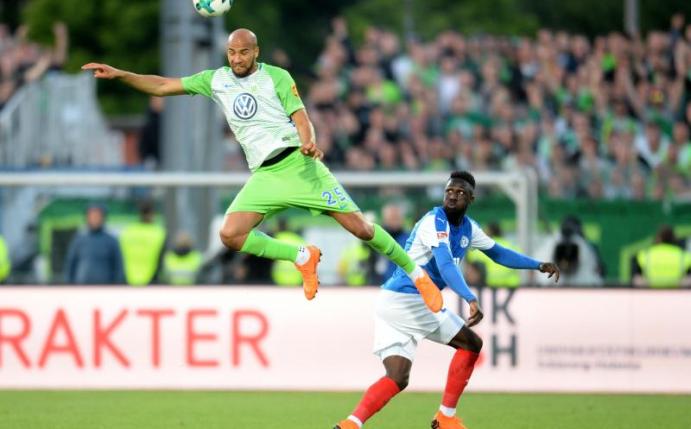 Wolfsburgs Brooks (l) und Kiels Schindler kämpfen um den Ball. Wolfsburg setzt sich in der Relegation durch. Foto: D. Bockwoldt