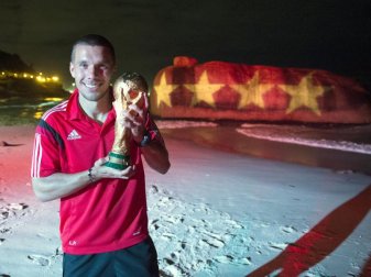 Goldjunge: Lukas Podolski mit dem WM-Pokal 2014. Foto: Ges/Markus Gilliar Goldjunge: Lukas Podolski mit dem WM-Pokal 2014. Foto: Ges/Markus Gilliar