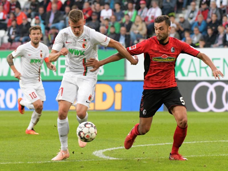 Augsburgs Alfred Finnbogason (l) war auch von Freiburgs Manuel Gulde nicht zu stoppen. Foto: Stefan Puchner