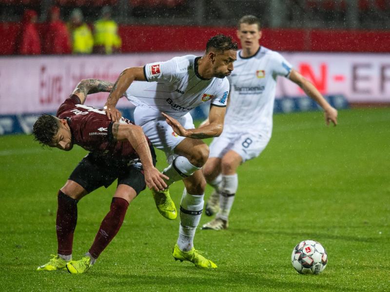 Nürnbergs Tim Leibold (l) Bayer-Profi Karim Bellarabi in den Weg. Foto: Nicolas Armer