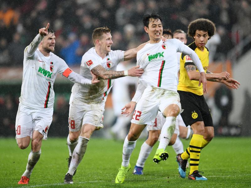 Augsburgs Daniel Baier (l-r), André Hahn und Dong-Won Ji jubeln über den Treffer zum 2:0 durch Ji. Foto: Tobias Hase