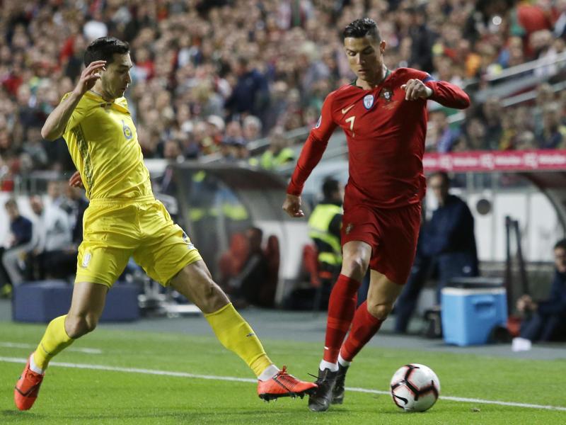 Portugals Superstar Cristiano Ronaldo (r) wird vom Ukrainer Taras Stepanenko unter Druck gesetzt. Foto: Armando Franca/AP