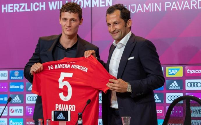 Weltmeister Benjamin Pavard (l) wird von Bayern-Sportdirektor Hasan Salihamidzic begrüßt. Foto: Peter Kneffel