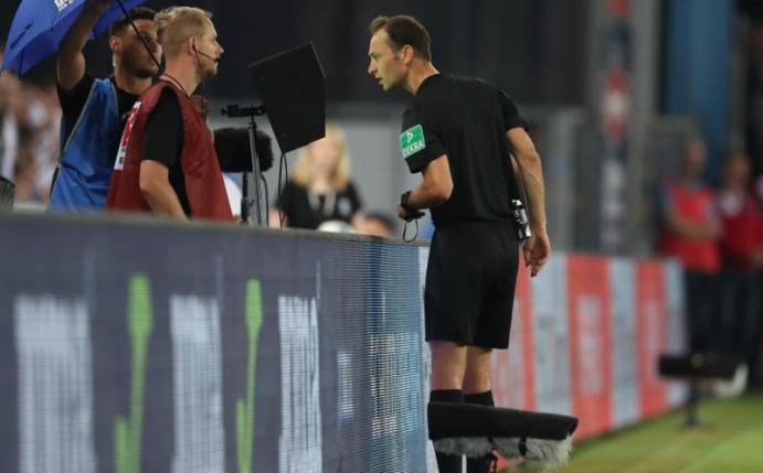 Schiedsrichter Bastian Dankert bedient sich des Videobeweises beim Spiel Bielefeld gegen St. Pauli. Foto: Friso Gentsch