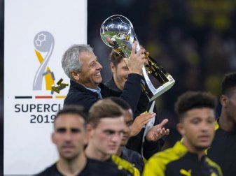 Trägt nach der Siegerehrung den Pokal eigenhändig vom Podest: Dortmunds Trainer Lucien Favre mit Supercup. Foto: Guido Kirchner Trägt nach der Siegerehrung den Pokal eigenhändig vom Podest: Dortmunds Trainer Lucien Favre mit Supercup. Foto: Guido Kirchner