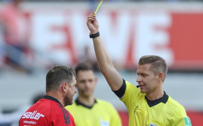 Schiedsrichter Tobias Welz (r) zeigt Paderborn-Trainer Baumgart (l) die erste Gelbe Karte. Foto: Friso Gentsch