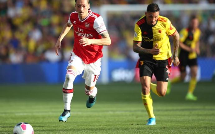 Arsenals Mesut Özil (l) und Jose Holebas von FC Watford im Laufduell. Foto: Nick Potts/PA Wire