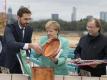 Bundeskanzlerin Agela Merkel (M) packt bei der Grundsteinlegung zur DFB-Akademie mit an. Foto: Boris Roessler