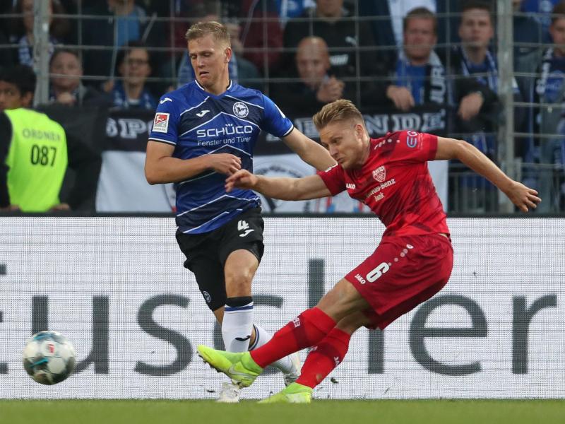 Bielefelds Joakim Nilsson (l) im Kampf um den Ball mit Santiago Ascacibar (r) vom VfB Stuttgart. Foto: Friso Gentsch