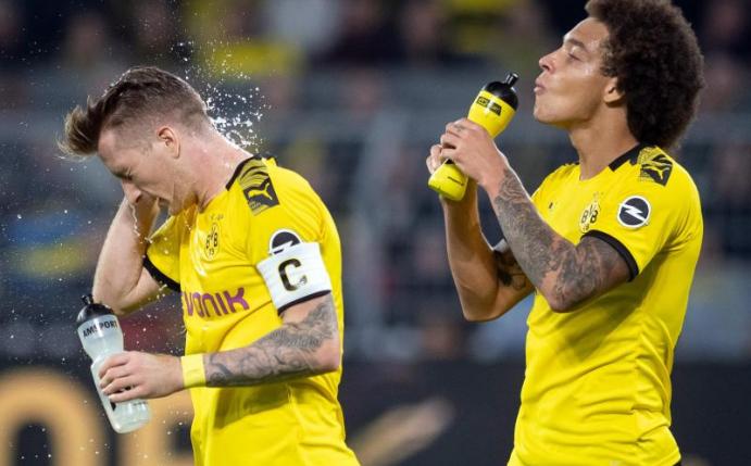 Die Dortmunder Marco Reus (l) und Axel Witsel erfrischen sich nach der Partie gegen den SV Werder Bremen. Foto: Bernd Thissen