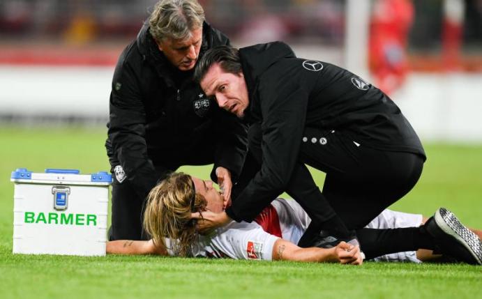 Borna Sosa vom VfB Stuttgart wird von den Mannschaftsärzten behandelt. Foto: Tom Weller/dpa