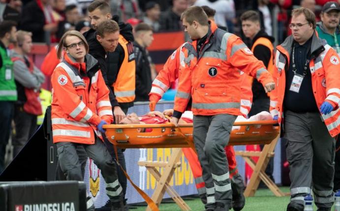 Leverkusens Charles Aranguiz wird verletzt vom Platz getragen und Leipzigs Trainer Julian Nagelsmann versucht zu trösten. Foto: Federico Gambarini/dpa